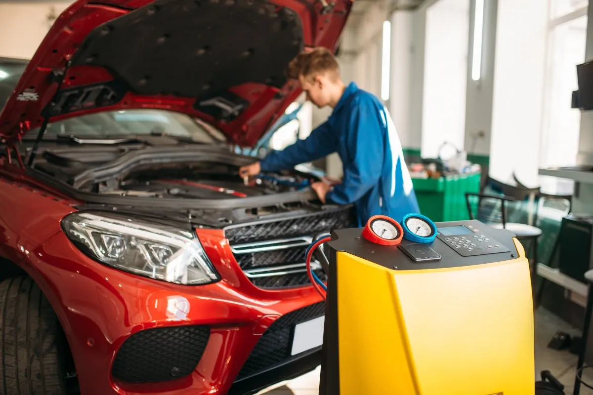Air conditioning recharge machine in use on a car in the workshop