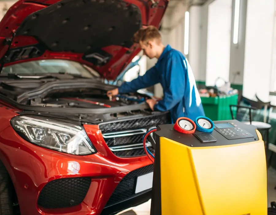 Air conditioning recharge machine in use on a car in the workshop