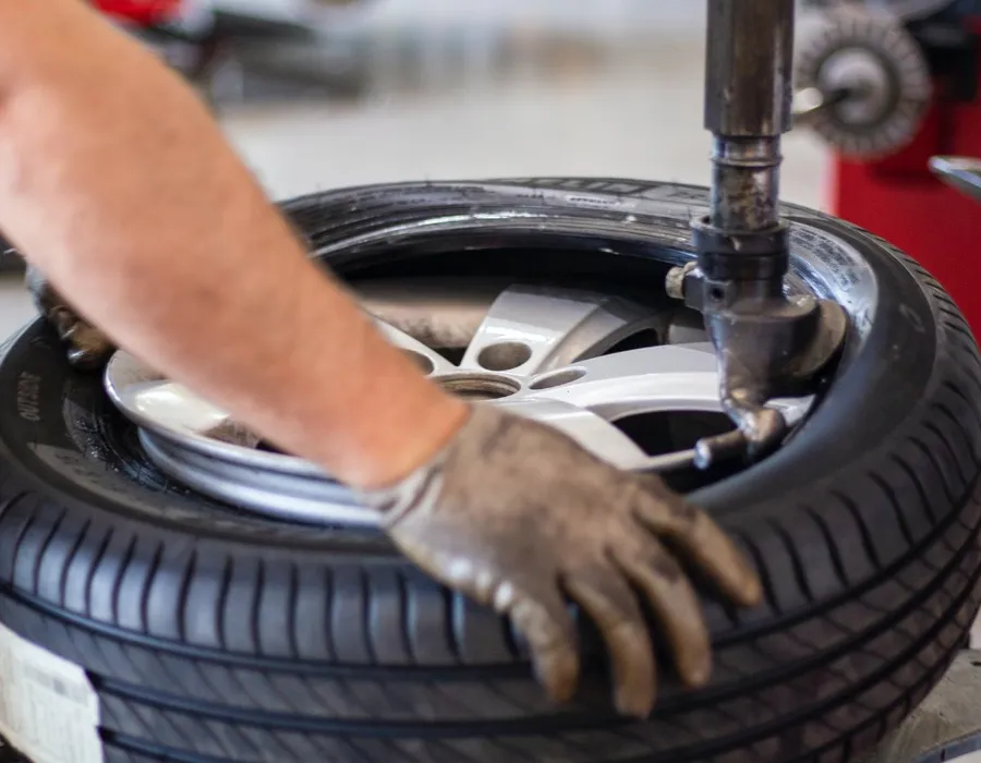 Technician fitting a tyre to an alloy wheel on a tyre machine