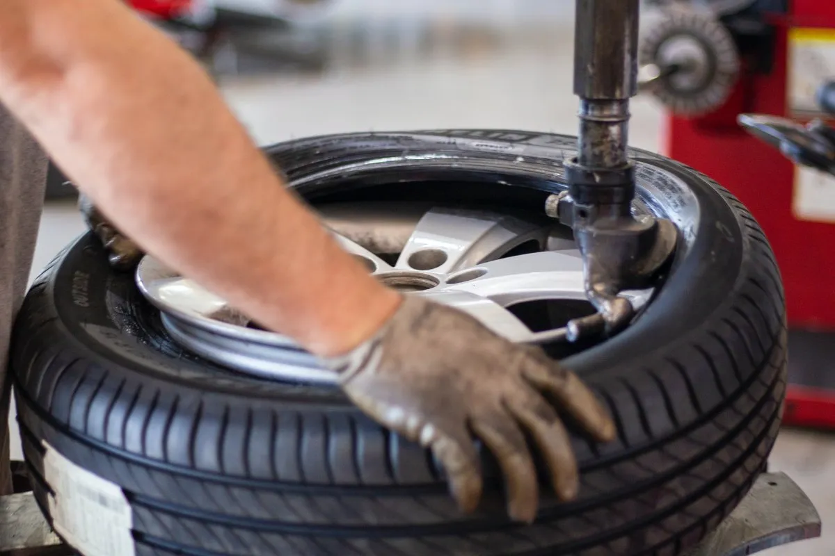 Technician fitting a tyre to an alloy wheel on a tyre machine